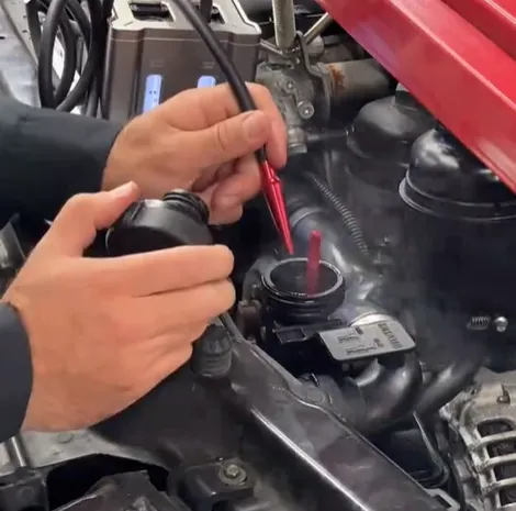 Mechanic diagnosing severe intake manifold leak symptoms using a smoke machine.