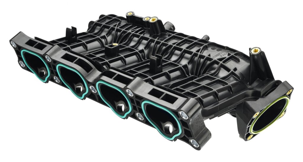 Professional mechanic working on a heavy-duty diesel engine intake manifold gasket replacement.